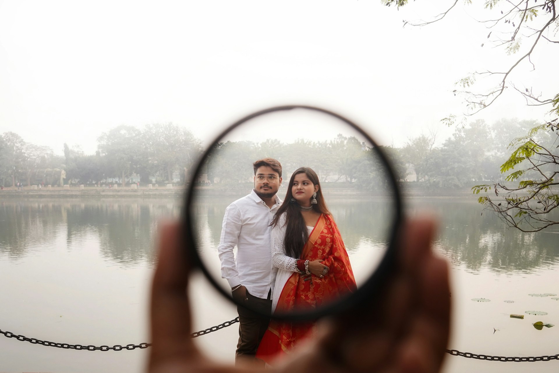a man and woman standing next to each other holding a magnifying glass